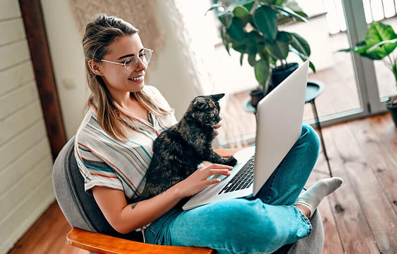 woman with her cat researching computer
